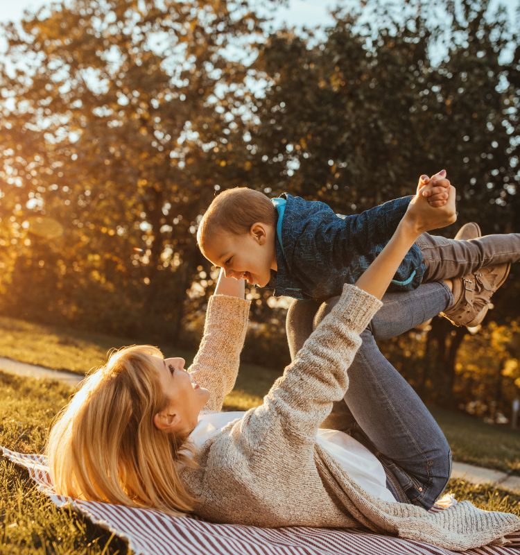 Mother and child embracing Calm parenting and nervous system regulation outdoors together. Learn more about nervous system regulation and parenting at www.shineom.com.au