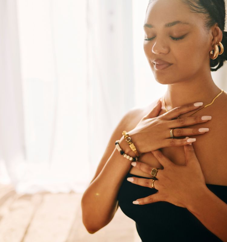 Mother with hand on heart practicing breath and nervous system regulation. 

Visit www.shineom.com.au to learn tools for self regulation in parenthood.