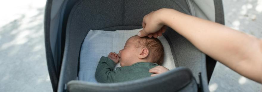 cute baby sleeping in gray stroller